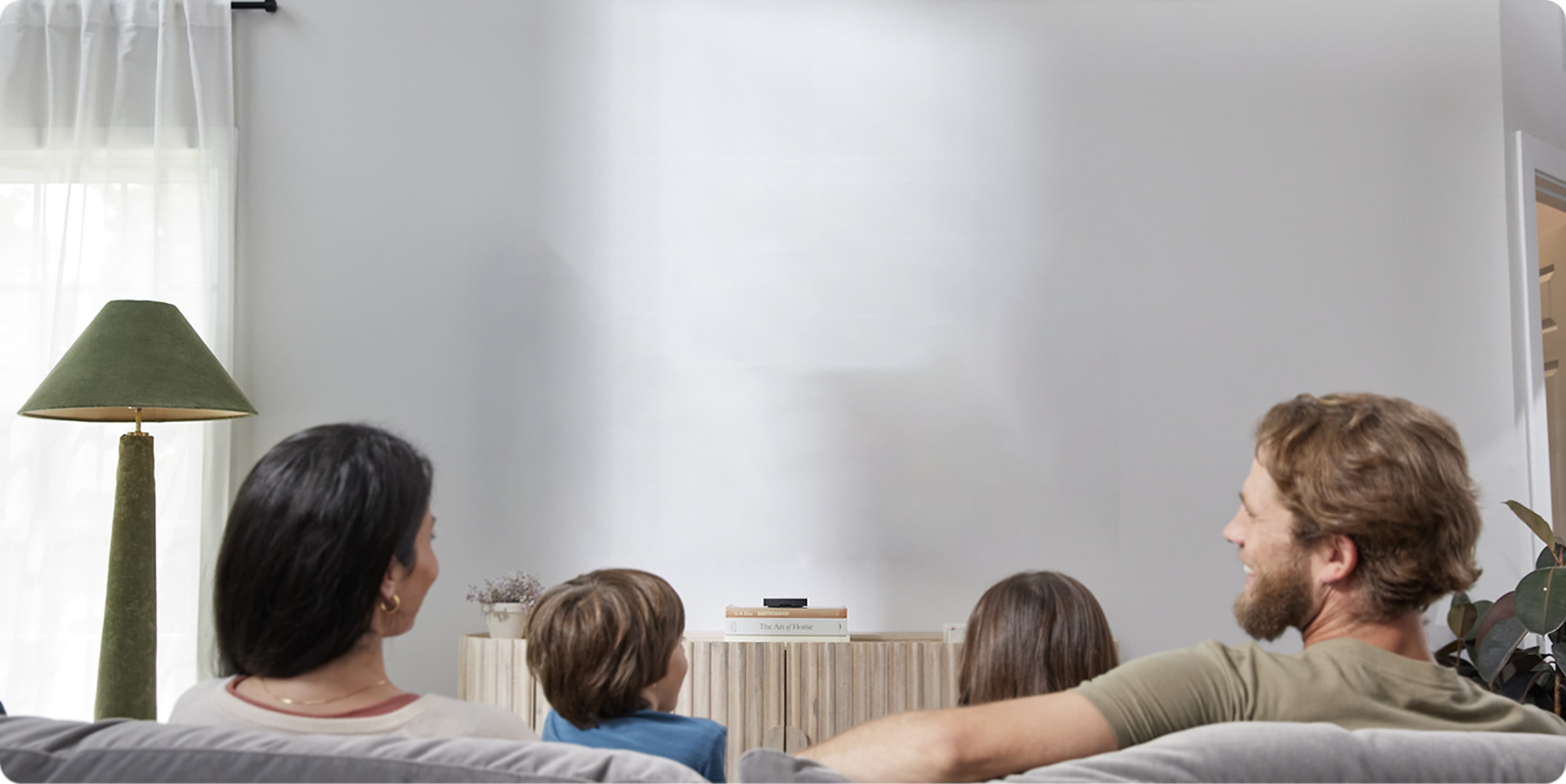 A picture of a family enjoying a Xumo Stream Box showing Penguin from HBO.